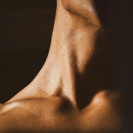 Close up image of a woman’s neck with a black background.