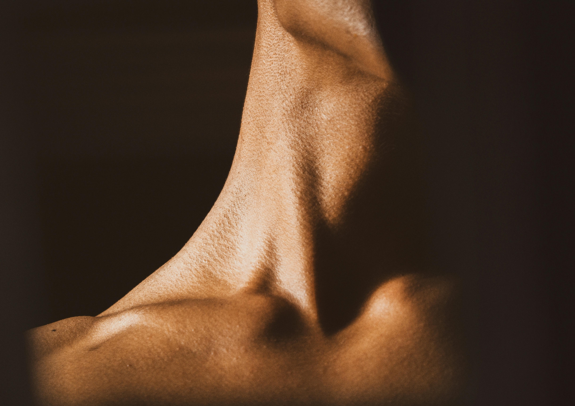 Close up image of a woman’s neck with a black background.